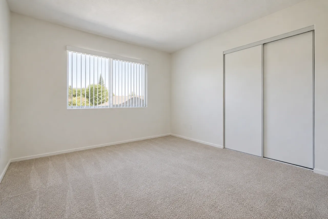 Empty apartment bedroom with light carpet ready for turnover